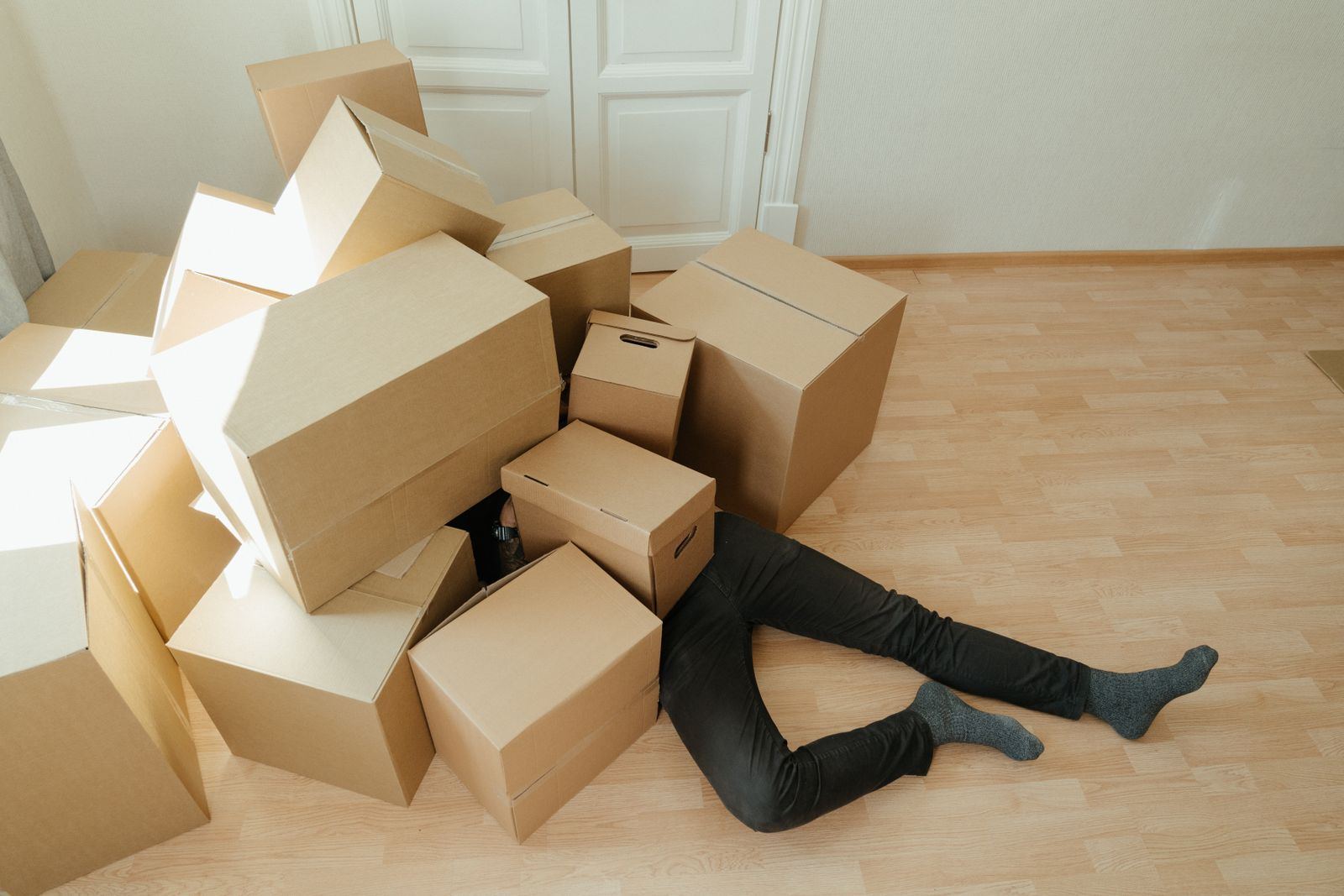 Cardboard moving boxes stacked in a bright empty room