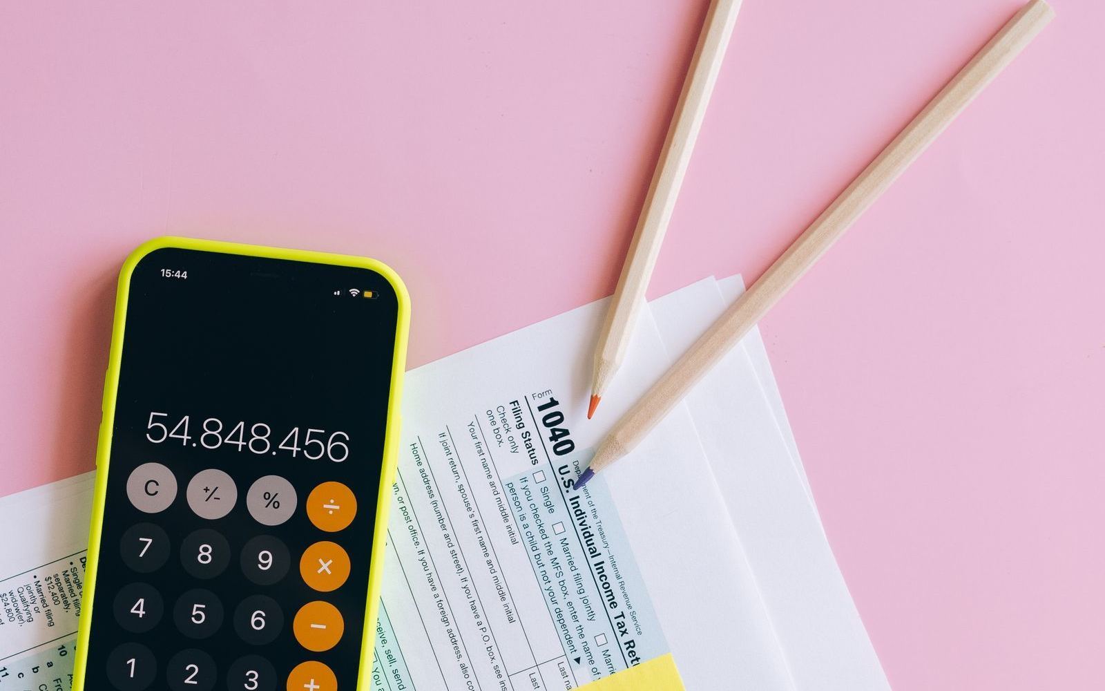 A calculator and paperwork spread across a desk