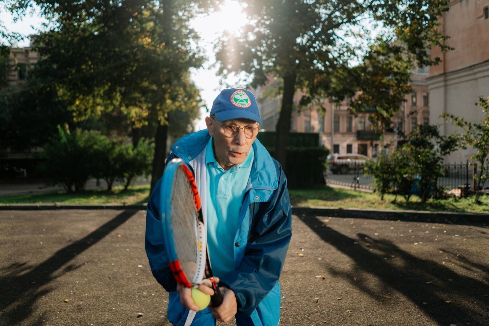 An active older adult playing tennis outdoors in the sunshine